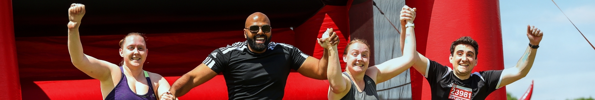 team-jump-off-an-obstacle-while-holding-hands-at-the-inflatable-5k