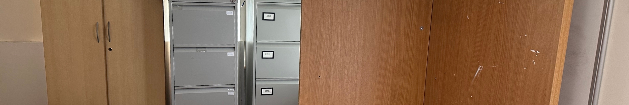 office-cupboard-filing-cabinets-and-desk-propped-in-a-corner-ready-for-removal