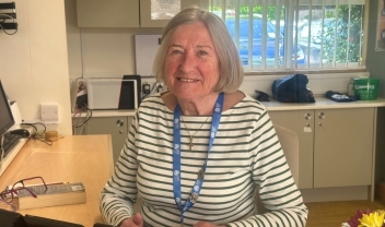 volunteer-receptionist-smiling-behind-reception-counter