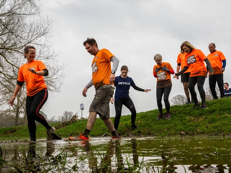 team-crossing-a-stream-at-muddy-mayhem