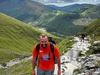 hiker-wearing-national-three-peaks-challenge-t-shirt-smiles-as-he-climbs-mountain