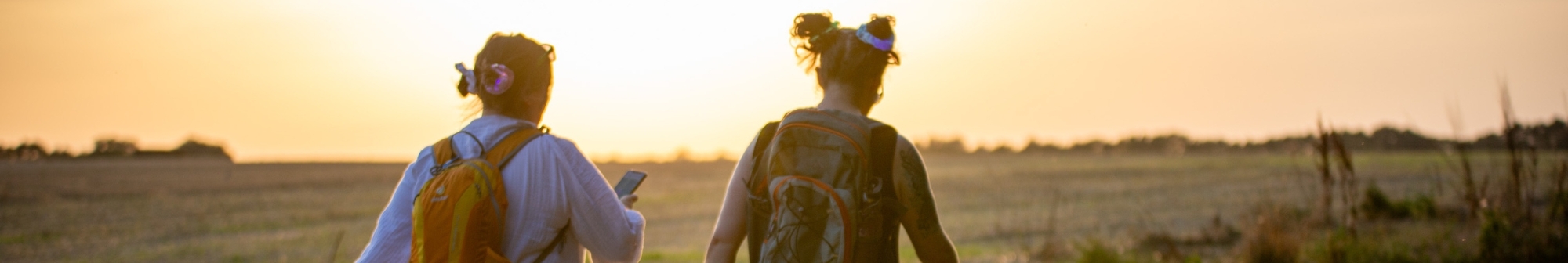 two-ladies-walking-away-from-the-camera-with-the-sunset-in-the-background