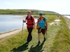 two-hikers-smile-at-the-camera-as-they-pass-a-lake-on-the-south-coast-ultra-challenge