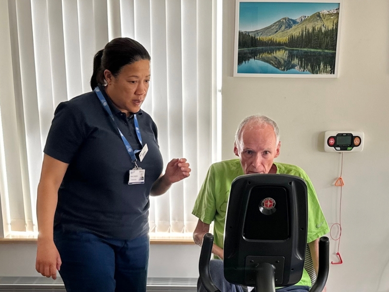 physiotherapist-observes-patient-on-exercise-bike