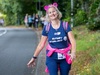 woman-smiles-walking-next-to-road-and-wearing-pink-animal-ears