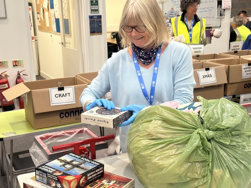 volunteer-sorting-a-bag-of-donations-at-the-depot