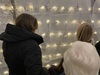 a-family-reading-messages-on-paper-stars-hanging-in-a-gazebo