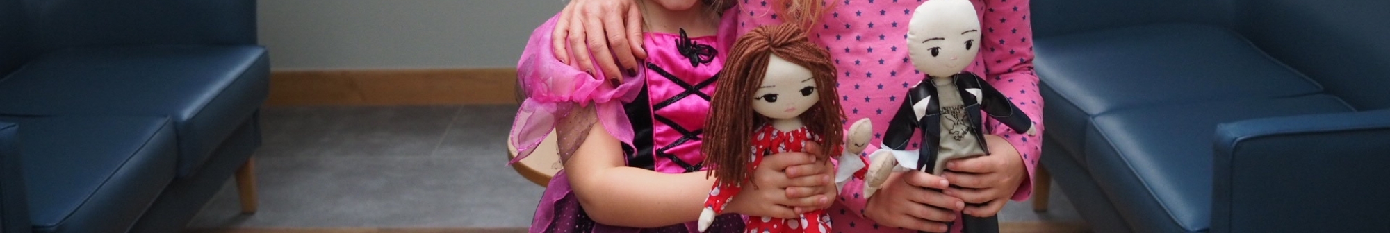 two-young-girls-hold-their-therapy-dolls