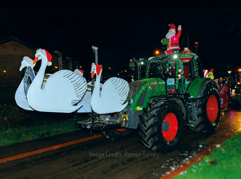 green-tractor-decorated-with-four-cardboard-swans-wearing-christmas-hats
