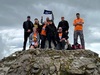 group-of-challengers-wave-garden-house-hospice-care-flag-at-scafell-pike-peak