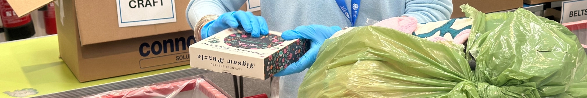 close-up-of-a-volunteers-hands-sorting-a-bag-of-donations