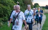 family-smile-and-wave-at-camera-on-walk