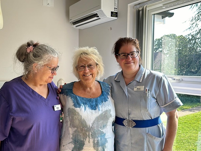 ipu-patient-polly-stands-and-smiles-with-nurses