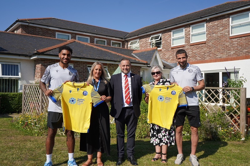 players-hospice-reps-and-stevenage-CEO-hold-up-third-kits-jerseys