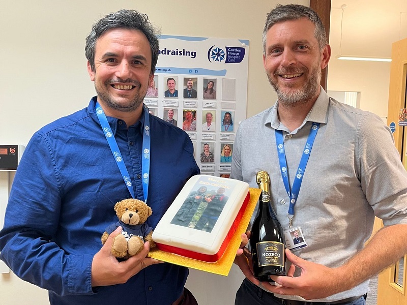 erman-and-adam-smile-outside-the-fundraising-office-holding-cake-and-processo