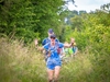 a-walker-waves-at-the-camera-through-long-grass-on-the-gower-peninsula-ultra-challenge